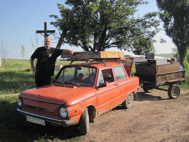 A man standing next to an old car.